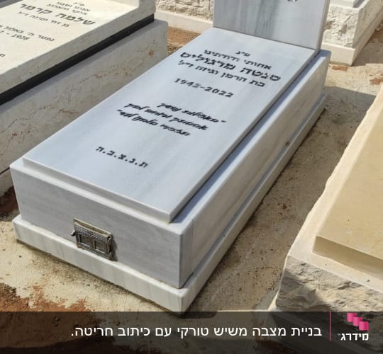 מצבת שיש בהיר יחידה עם חריטת כיתוב בשחור ובית נר מובנה